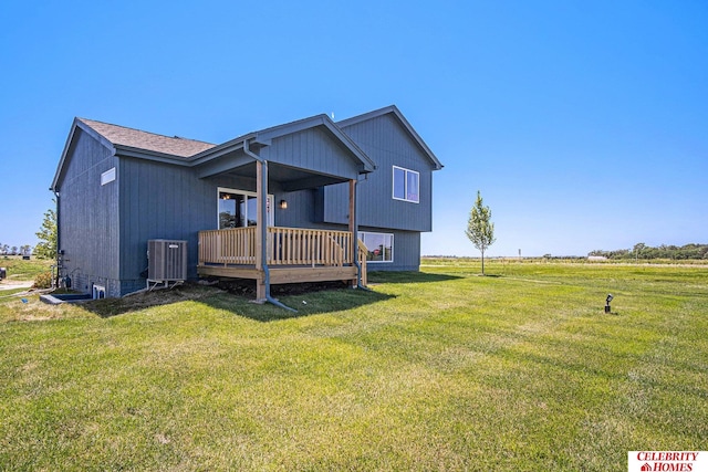 back of property with a deck, a lawn, and central AC unit