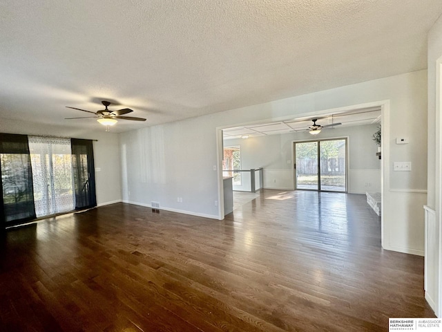 unfurnished room with dark hardwood / wood-style floors, a textured ceiling, and ceiling fan