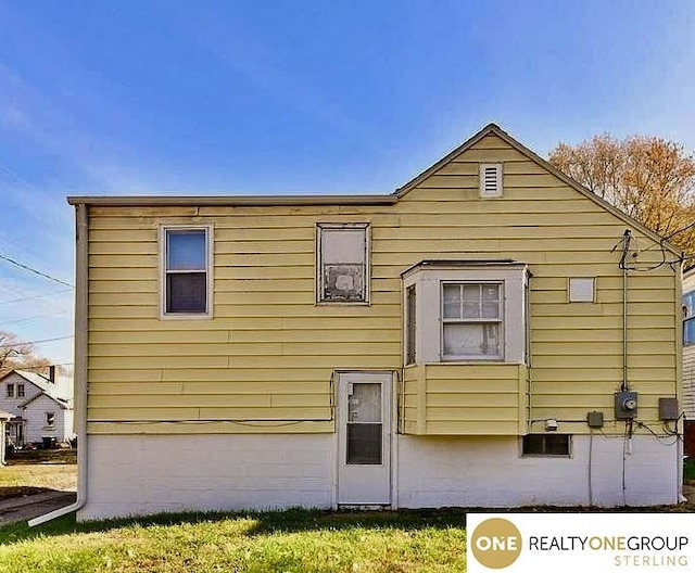 rear view of property with a lawn