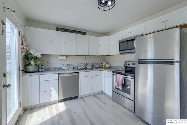7336 S 71st Ave, Omaha, NE 68128 - kitchen featuring appliances with stainless steel finishes, white cabinets, and light wood-style floors