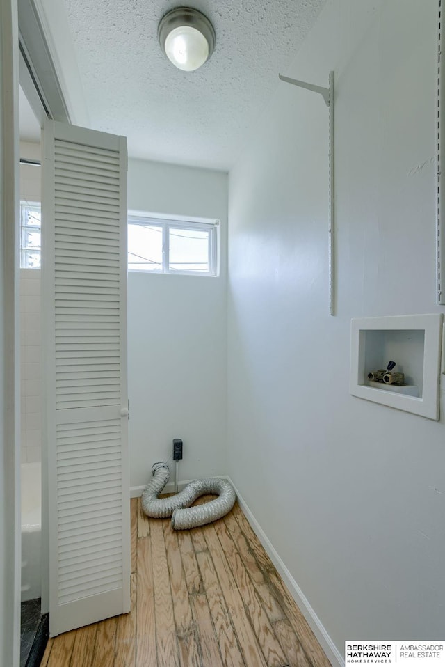 7336 S 71st Ave, Omaha, NE 68128 - laundry room featuring washer hookup, a textured ceiling, and light wood-type flooring
