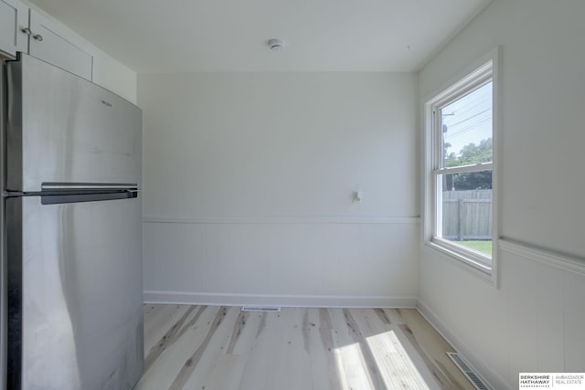 7336 S 71st Ave, Omaha, NE 68128 - unfurnished dining area with light wood finished floors and a wainscoted wall