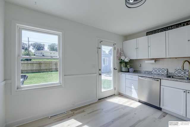 7336 S 71st Ave, Omaha, NE 68128 - kitchen featuring stainless steel dishwasher, light wood-style floors, white cabinetry, and decorative backsplash