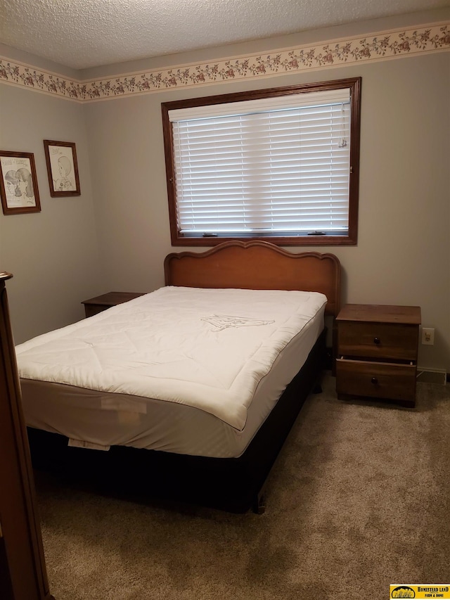 bedroom with carpet floors and a textured ceiling