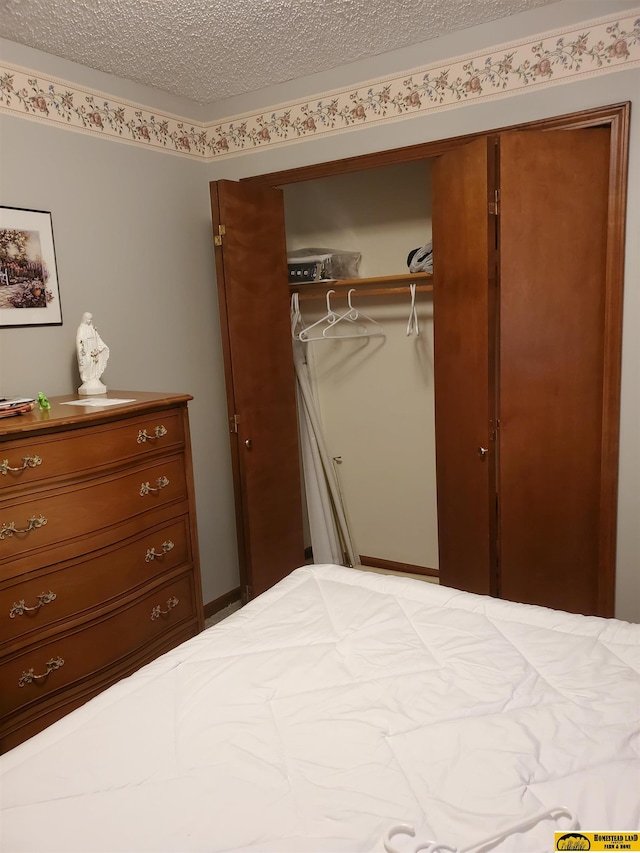 bedroom with a textured ceiling and a closet