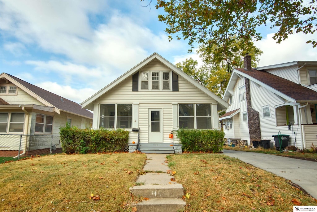 bungalow featuring a sunroom and a front lawn