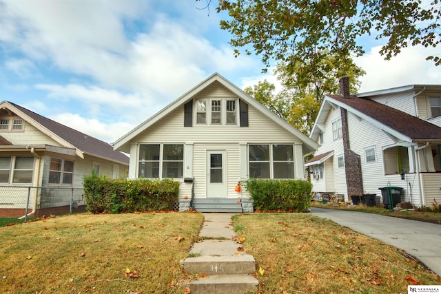 bungalow featuring a sunroom and a front lawn