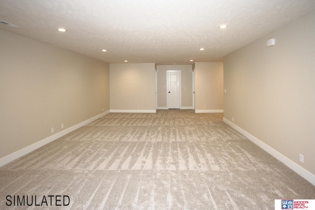 spare room featuring light carpet and a textured ceiling