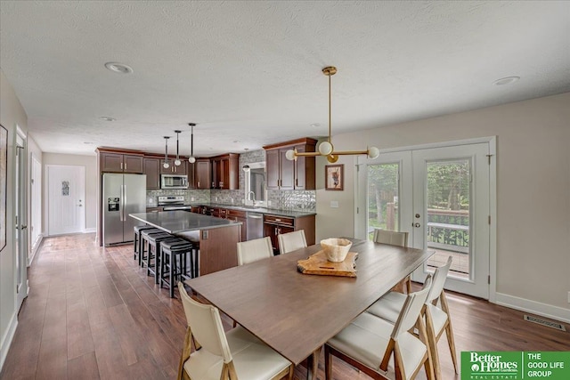 dining room with french doors, a textured ceiling, and dark hardwood / wood-style flooring