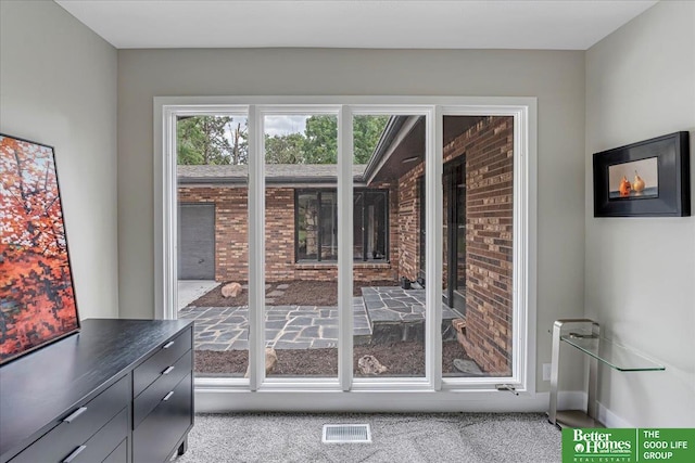 doorway to outside featuring light colored carpet