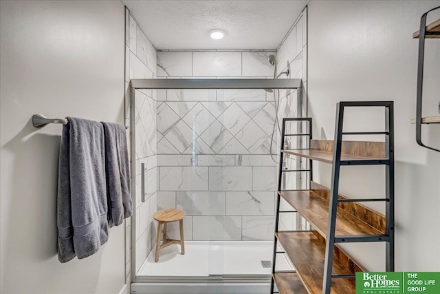 bathroom featuring a shower with shower door and a textured ceiling