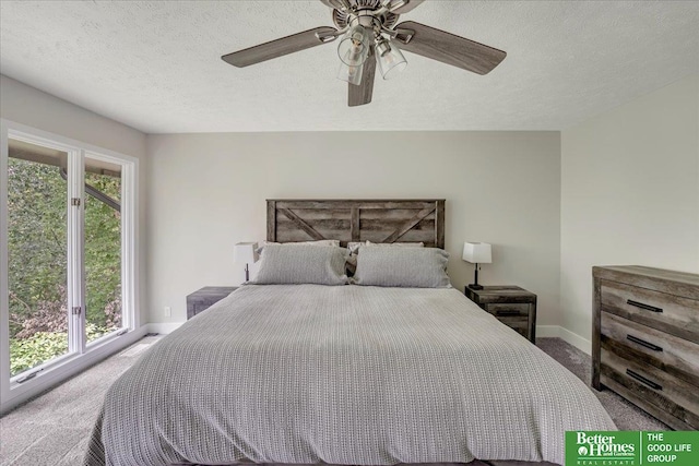 carpeted bedroom with ceiling fan and a textured ceiling