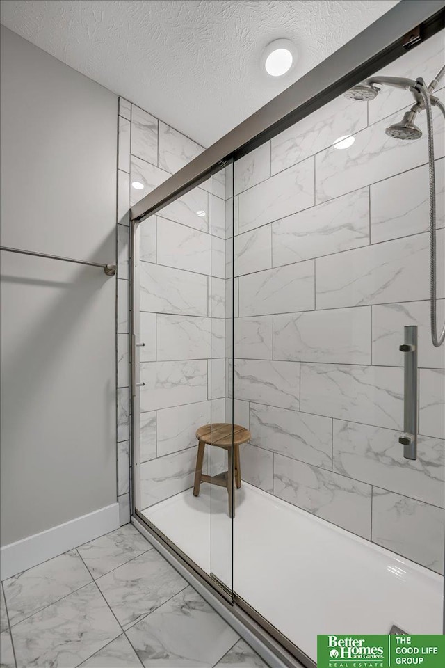 bathroom featuring a textured ceiling and walk in shower