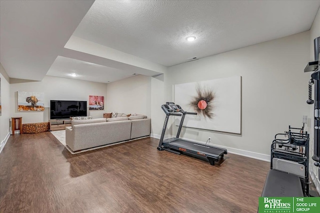 exercise area featuring a textured ceiling and dark hardwood / wood-style floors