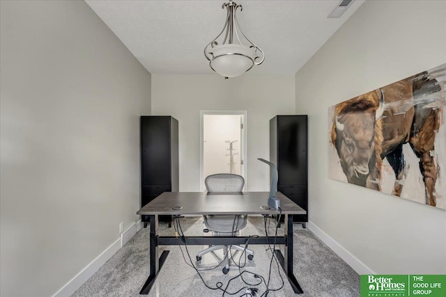 carpeted home office with a textured ceiling