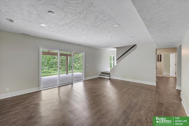 empty room featuring dark wood-type flooring and a textured ceiling