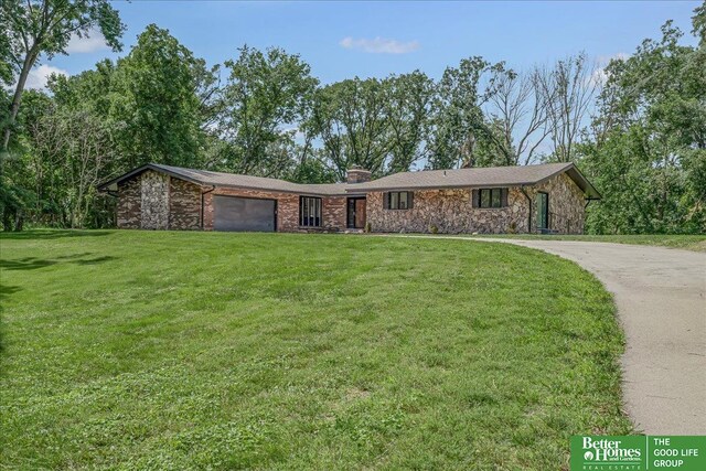 ranch-style home with a front lawn and a garage