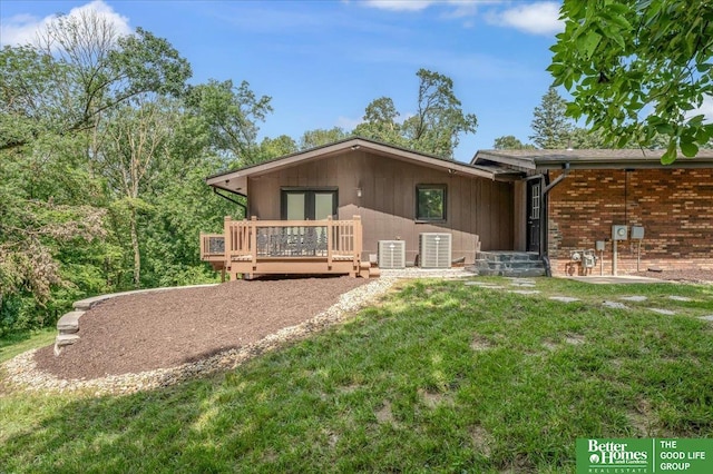 rear view of property featuring a patio, a deck, a yard, and central AC unit