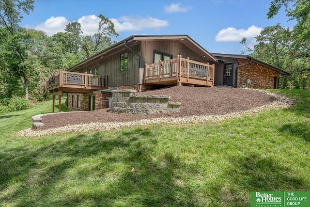 rear view of property featuring a wooden deck and a yard