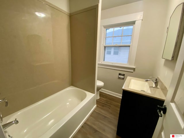 full bathroom with washtub / shower combination, vanity, wood-type flooring, and toilet