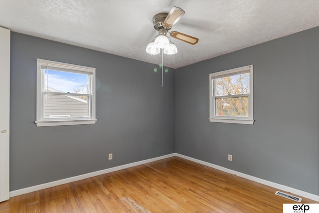 spare room featuring light hardwood / wood-style flooring, a textured ceiling, and ceiling fan