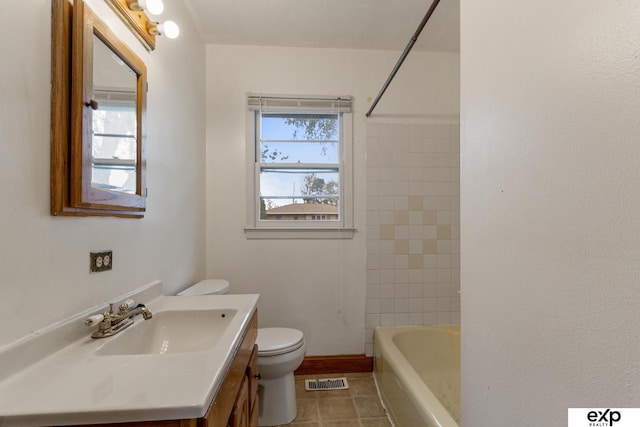 full bathroom with toilet, tiled shower / bath, vanity, and tile patterned floors