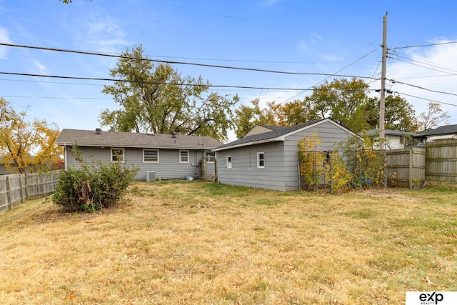 rear view of property with a yard and cooling unit