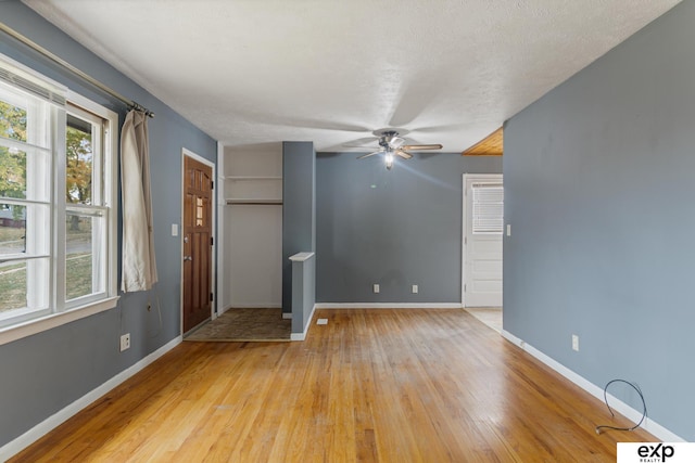 interior space featuring ceiling fan, a textured ceiling, and light hardwood / wood-style flooring