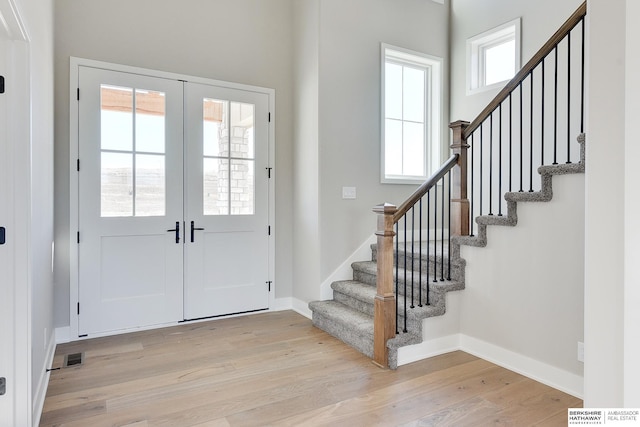 entryway featuring french doors, plenty of natural light, and light wood-type flooring