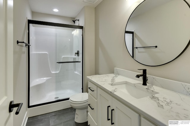 bathroom with vanity, toilet, and a shower with door