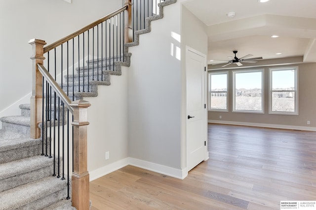 stairway with hardwood / wood-style flooring and ceiling fan