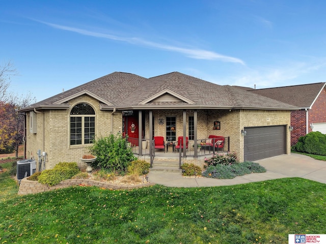 ranch-style house with covered porch, a front lawn, and a garage