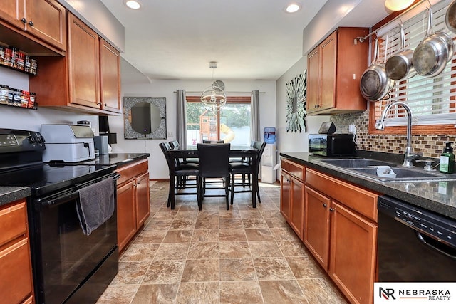 kitchen featuring tasteful backsplash, hanging light fixtures, black appliances, and sink