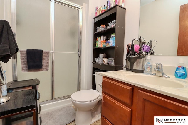 bathroom featuring vanity, toilet, and an enclosed shower