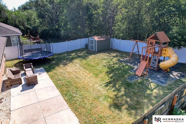 view of yard featuring a storage unit, a playground, and a trampoline