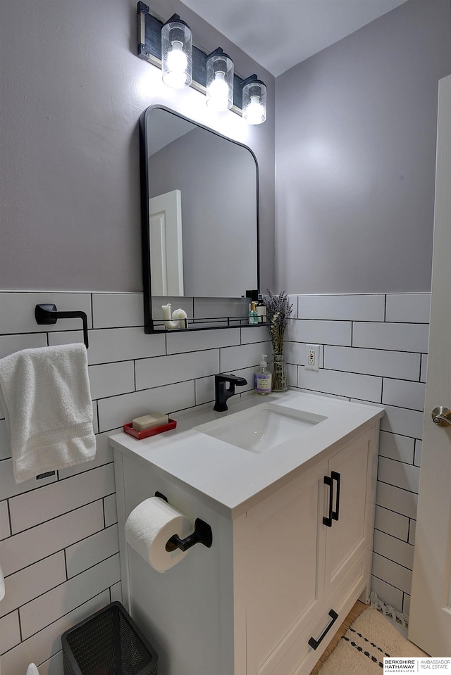 bathroom with vanity and tile walls