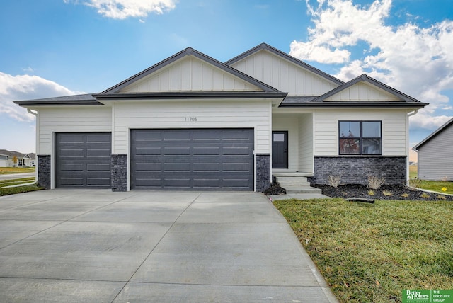 11705 Port Royal Dr, Papillion, NE 68046 - view of front of property with a garage, concrete driveway, board and batten siding, and stone siding