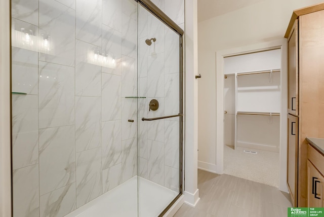 bathroom with vanity, walk in shower, and tile patterned flooring