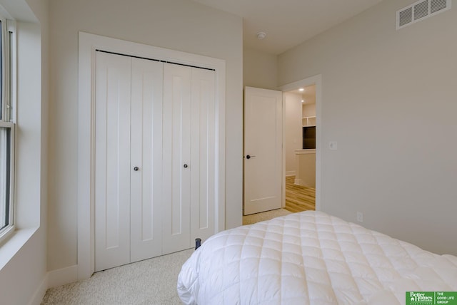 bedroom featuring a closet and light carpet