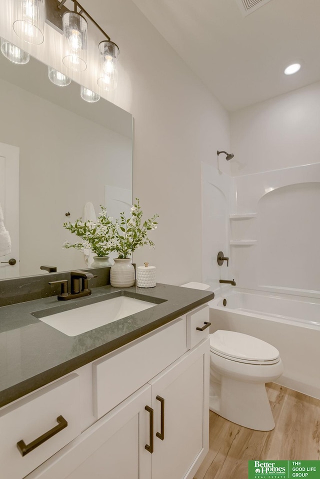 full bathroom featuring toilet, bathing tub / shower combination, vanity, and wood-type flooring