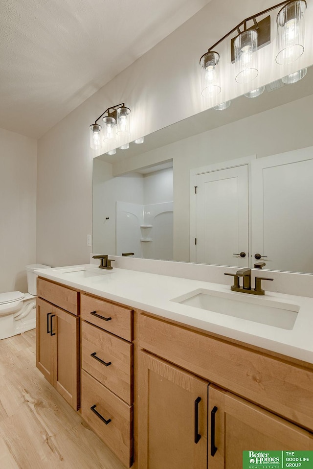 bathroom with vanity, toilet, walk in shower, and hardwood / wood-style floors