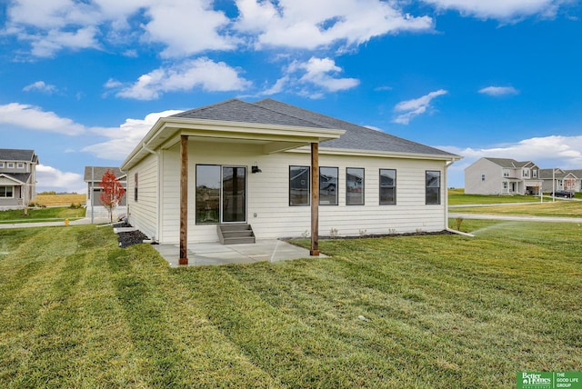 rear view of house featuring a patio area and a yard