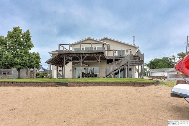 rear view of property with a wooden deck and a yard