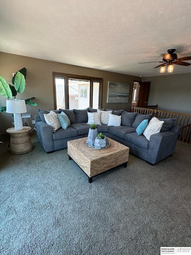 living room with a textured ceiling, carpet flooring, and ceiling fan