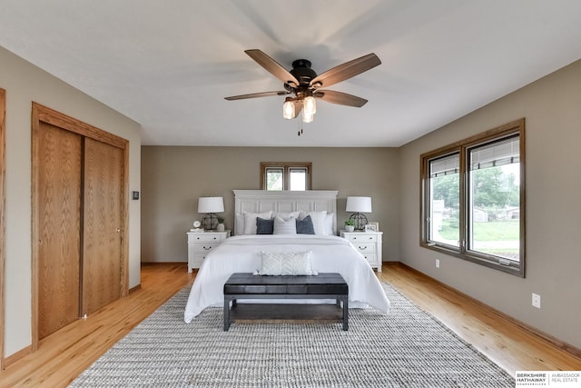 bedroom featuring a closet, light hardwood / wood-style floors, and ceiling fan