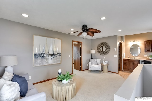 living room featuring light carpet, sink, and ceiling fan