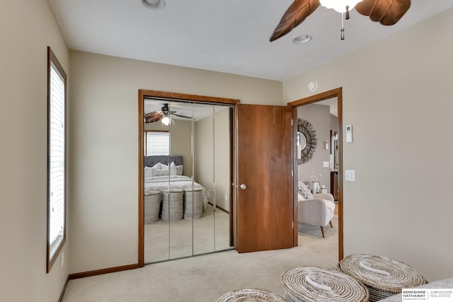 bedroom featuring light carpet, a closet, and ceiling fan