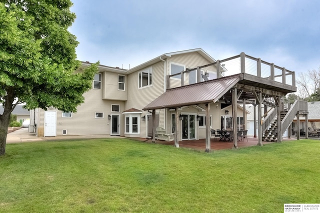 back of house featuring a patio area, a deck, and a lawn