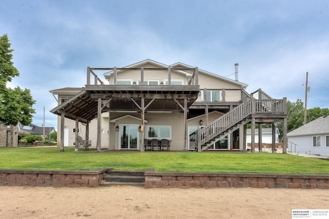 back of property featuring a wooden deck and a yard