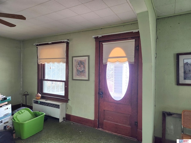 foyer with radiator, plenty of natural light, and baseboards